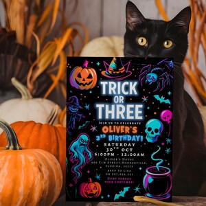 May include: A Halloween-themed invitation with the text "Trick or Three" and a variety of spooky illustrations, including pumpkins, a witch's hat, a spider, and a skull. The invitation is set against a black background and features a black cat.