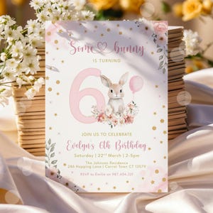 以下が含まれることがあります： 「Some bunny is turning 6」の文字が入った、ピンクと白の誕生日招待状。風船を持ったウサギ、花、金色の星が描かれています。エブリンの6歳の誕生日の招待状です。