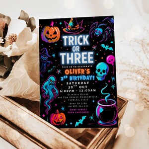 May include: A Halloween-themed invitation with the text "Trick or Three" in neon blue. The invitation features a pumpkin, witch hat, spider, ghost, skull, and cauldron illustrations. The invitation is for Oliver's 3rd birthday.