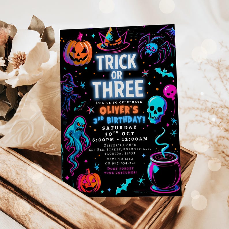 May include: A Halloween-themed invitation with the text "Trick or Three" in neon blue. The invitation features a pumpkin, witch hat, spider, ghost, skull, and cauldron illustrations. The invitation is for Oliver's 3rd birthday.