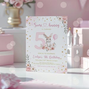 May include: A pink and white birthday invitation with the text "Some bunny is turning 5". The invitation features a watercolour illustration of a bunny holding a balloon, surrounded by flowers. The invitation includes the event details.