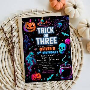 May include: Halloween-themed invitation with a black background and neon illustrations of a pumpkin, witch hat, spider, ghost, skull, and cauldron. The text reads "Trick or Three" and announces Oliver's 3rd birthday party.