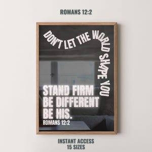 以下が含まれることがあります： 木製のフレームに入ったプリント。プリントには、白い文字で「DON'T LET THE WORLD SHAPE YOU STAND FIRM BE DIFFERENT BE HIS」と書かれており、上部と下部に「ROMANS 12:2」と書かれています。背景はぼやけたインテリアです。