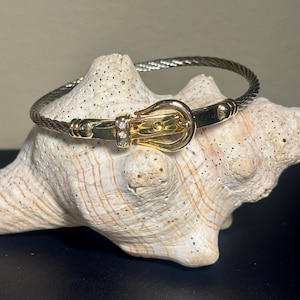 May include: A set of three ceramic mugs with a speckled, matte finish. The mugs are in shades of cream, light gray, and dark gray. Each mug has a simple, minimalist design, perfect for coffee or tea.