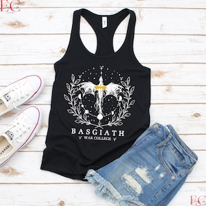 May include: Black racerback vest with a white graphic design featuring a dragon, a cross, and the text "BASGIATH WAR COLLEGE". The vest is paired with denim shorts and white trainers.