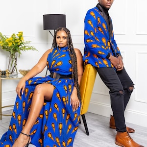 May include: A sleeveless blue dress with a high neckline, a black waist belt, and a high leg slit, featuring an orange and yellow teardrop pattern. A blue blazer with a black lapel and the same teardrop pattern, paired with black jeans.