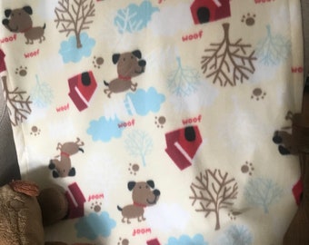 fleece pet blanket (small/medium) for a dog, with a cream background, brown dog in yard, with trees and dog house, it measures 27"x34"