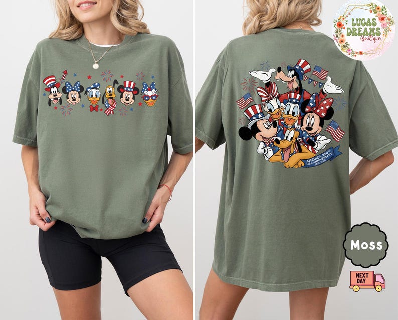 以下が含まれることがあります： モスグリーンのTシャツ。愛国的な漫画のデザインが特徴です。前面には、お祝いの帽子と花火をかぶった6人のキャラクターが描かれています。背面には、アメリカの国旗を持ったキャラクターのグループと「America 250th USA Anniversary」の文字が描かれています。