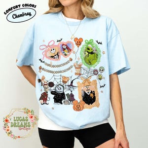 Puede incluir: Camiseta azul claro con un gr&aacute;fico colorido de personajes de Pesadilla antes de Navidad. El dise&ntilde;o incluye a Jack Skellington, Sally, Oogie Boogie y otros personajes en marcos ornamentados, con murci&eacute;lagos y estrellas. La camiseta tiene el texto "Comfort Colors Chambray".
