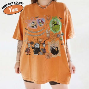Puede incluir: Camiseta naranja con un dise&ntilde;o de personajes de "Pesadilla antes de Navidad". El dise&ntilde;o incluye a Jack Skellington, Sally, Oogie Boogie y otros personajes. La camiseta tiene las palabras "Comfort Colors" y "Yam" impresas.