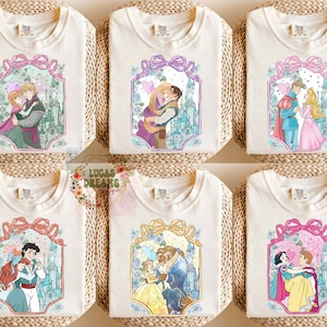 Puede incluir: Camisetas color crema con parejas de princesas Disney en marcos ornamentados con lazos y detalles florales. Cada dise&ntilde;o muestra una pareja diferente, con fondos de castillos y paletas de colores pastel.