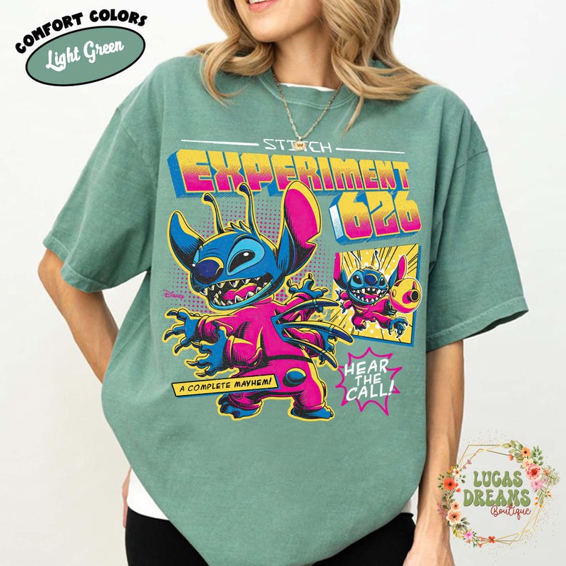 May include: Light green t-shirt featuring a colorful graphic of Stitch, Experiment 626, with the text "STITCH EXPERIMENT 626", and the phrases "A COMPLETE MAYHEM!" and "HEAR THE CALL!". The shirt is a comfort color.