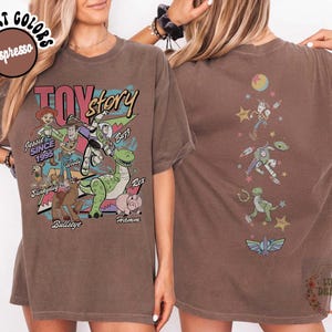 May include: Espresso-colored t-shirt featuring a Toy Story graphic. The front displays characters like Woody, Buzz, and Rex, with the text "TOY STORY" and "Jessie Since 1995." The back shows additional characters. The shirt is a comfort color.