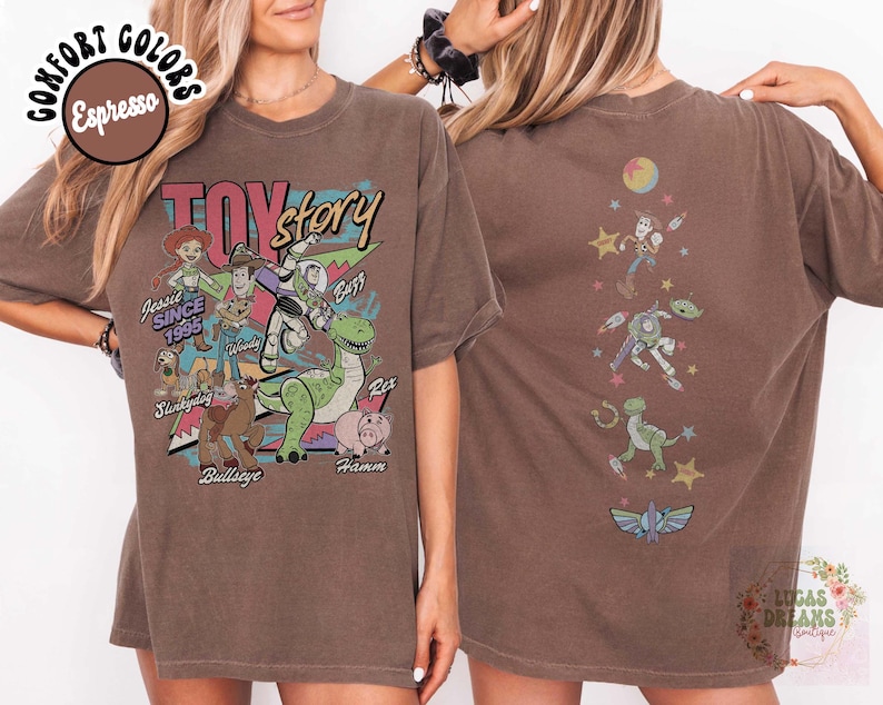 May include: Espresso-colored t-shirt featuring a Toy Story graphic. The front displays characters like Woody, Buzz, and Rex, with the text "TOY STORY" and "Jessie Since 1995." The back shows additional characters. The shirt is a comfort color.