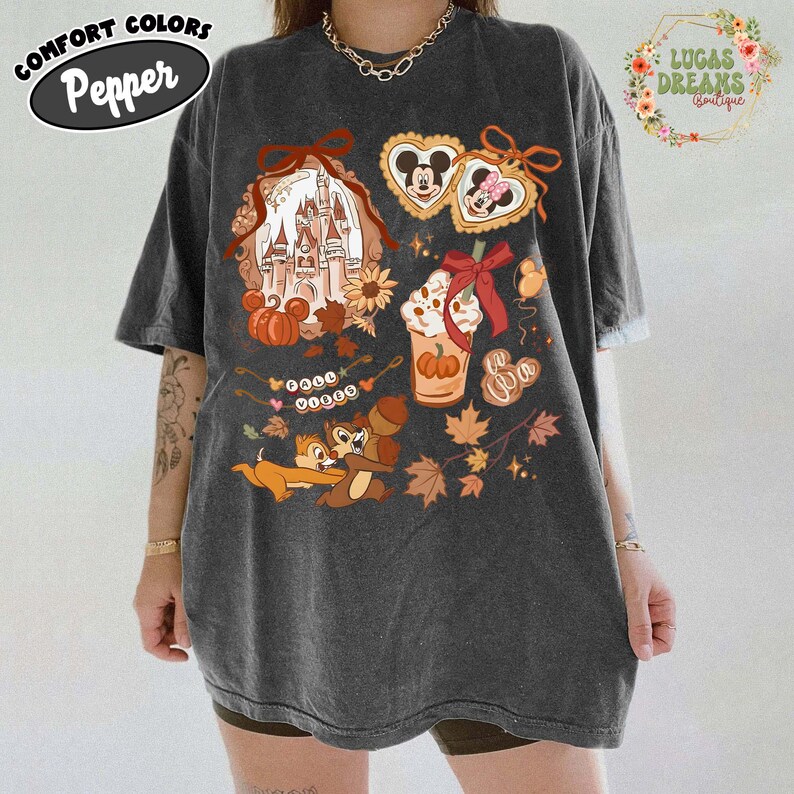 May include: Dark gray Comfort Colors t-shirt with a Disney-themed graphic. The design includes a castle, pumpkins, Mickey and Minnie Mouse cookies, a pumpkin spice latte, Chip and Dale, and autumn leaves. The shirt has the text "Pepper" on it.