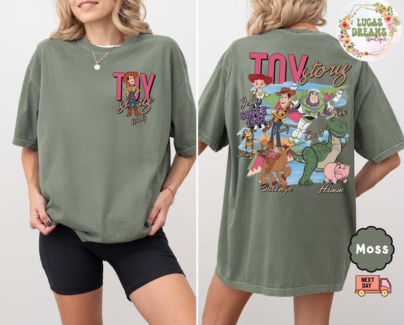 Peut inclure: T-shirt vert mousse avec le texte "Toy Story" et un dessin de Woody sur le devant. Le dos du t-shirt pr&eacute;sente divers personnages de Toy Story. Le t-shirt a une coupe ample et confortable.