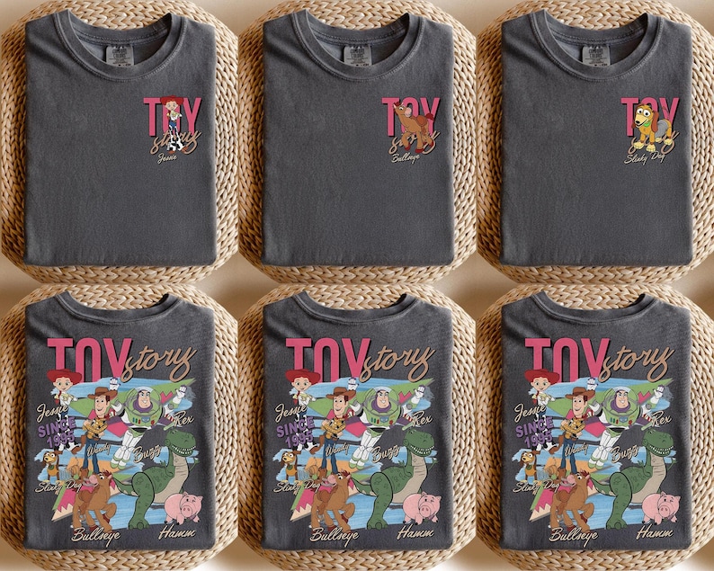 Peut inclure: T-shirts gris fonc&eacute; avec l'inscription rose "TOY STORY" et divers motifs de personnages. Certains t-shirts pr&eacute;sentent de petits graphismes, tandis que d'autres affichent un motif plus grand avec des personnages comme Woody, Buzz et Rex.