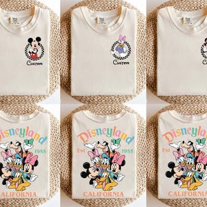 Puede incluir: Camisetas color crema con personajes de Disney. Algunas camisetas tienen dise&ntilde;os de Mickey, Daisy y Minnie Mouse con la palabra "Custom". Otras camisetas muestran "Disneyland Est. 1955 CALIFORNIA" con varios personajes de Disney.