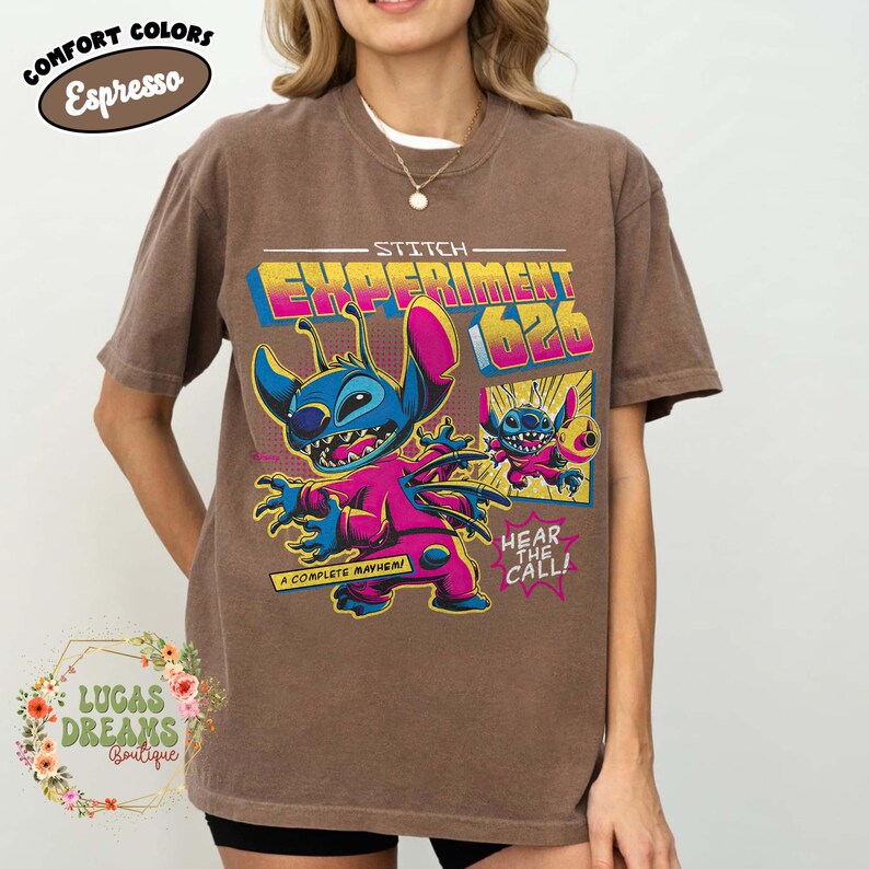 May include: Brown t-shirt featuring a graphic of Stitch from Lilo & Stitch, labeled "Experiment 626." The design includes Stitch in a pink jumpsuit with the text "A Complete Mayhem" and "Hear the Call!" The shirt is labeled "Comfort Colors Espresso."