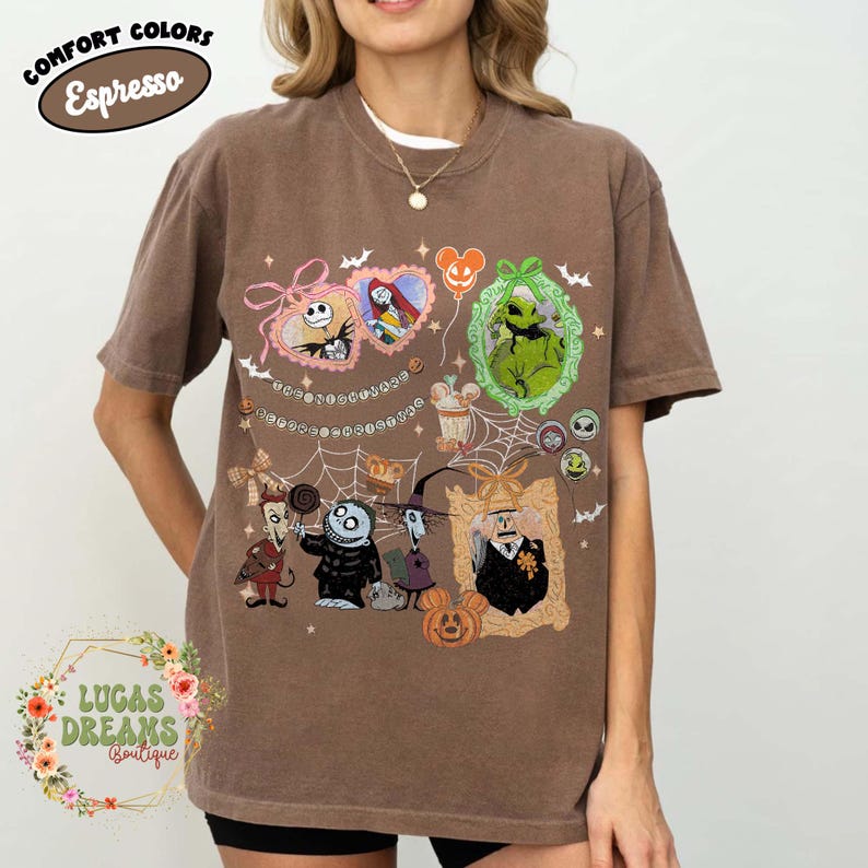 Puede incluir: Camiseta marr&oacute;n con un dise&ntilde;o que presenta personajes de The Nightmare Before Christmas. El dise&ntilde;o incluye a Jack Skellington, Sally, Oogie Boogie y otros personajes en retratos enmarcados y elementos decorativos. La camiseta tiene el texto "Comfort Colors" y "Espresso".