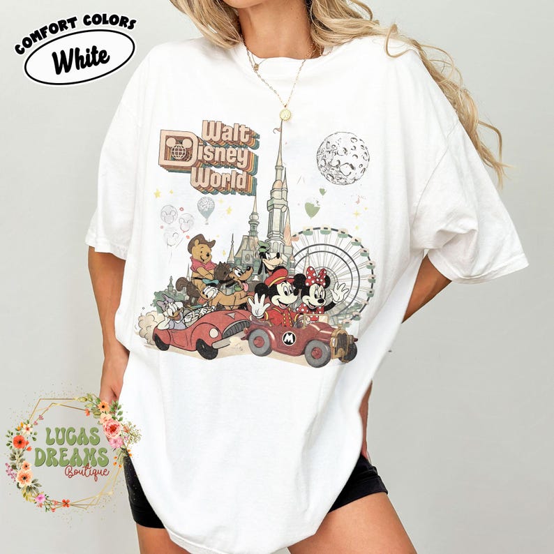 May include: White t-shirt with a vintage-style Walt Disney World graphic featuring Mickey and Minnie Mouse, Winnie the Pooh, and other characters in red cars. The shirt also has the text "Comfort Colors White" and "Lucas Dreams Boutique".
