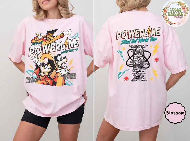 Puede incluir: Camiseta rosa claro con dise&ntilde;o de Powerline. La parte delantera muestra personajes de dibujos animados y el texto "POWERLINE" y "World Tour '95". La parte trasera presenta una lista de ciudades de la gira mundial.