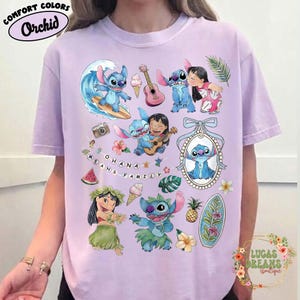 May include: Orchid Comfort Colors t-shirt featuring a colorful graphic of Stitch from Lilo & Stitch. The design includes Stitch surfing, playing guitar, and with Lilo. The phrase "OHANA MEANS FAMILY" is also displayed.