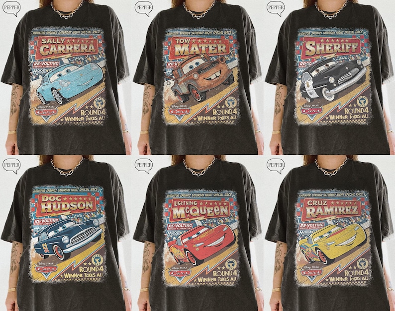 May include: Six dark gray t-shirts featuring different characters from the movie Cars. Each shirt has a vintage-style graphic with the character's name and a racing theme. The shirts are oversized.