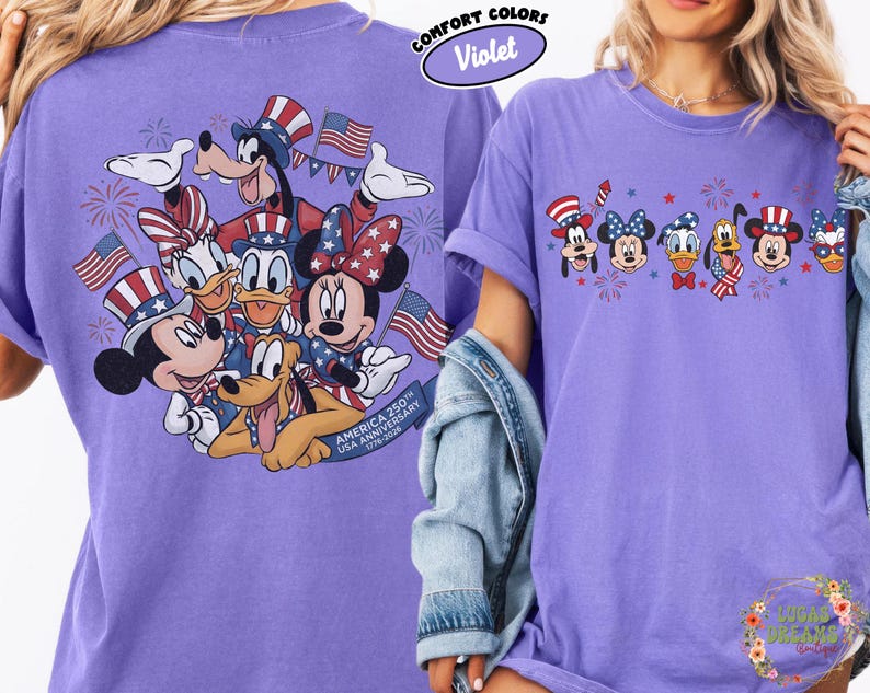 以下が含まれることがあります： 紫色のComfort Colors Tシャツ。ミッキー、ミニー、ドナルド、グーフィーなど、愛国的な衣装を着たディズニーのキャラクターが、アメリカの国旗と花火とともに描かれています。Tシャツの背面には、グラフィックの大きなバージョンがあります。「America 250th USA Anniversary 1776-2026」と書かれています。