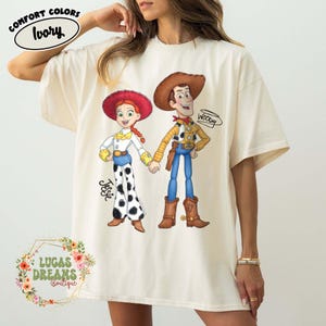 Camiseta de Disney Toy Story con Woody y Jessie, camiseta de pareja de Disney, camiseta de Magic Kingdom, camiseta de personajes de Toy Story, camiseta a juego para viajes familiares de Disney Ivory/Natural/Sand