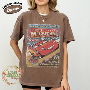 May include: Espresso-colored t-shirt featuring a graphic of Lightning McQueen from the movie Cars. The design includes the text "Lightning McQueen" and "Radiator Springs Saturday Night Special Race". The shirt also has the text "Winner Takes All".