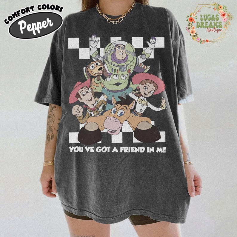 レトロなトイ・ストーリーTシャツ、君はともだちTシャツ、ディズニーファミリーバケーションTシャツ、フロントバックコンフォートカラーズTシャツ、レトロなピクサーグラフィックTシャツ Pepper/Dark Heather