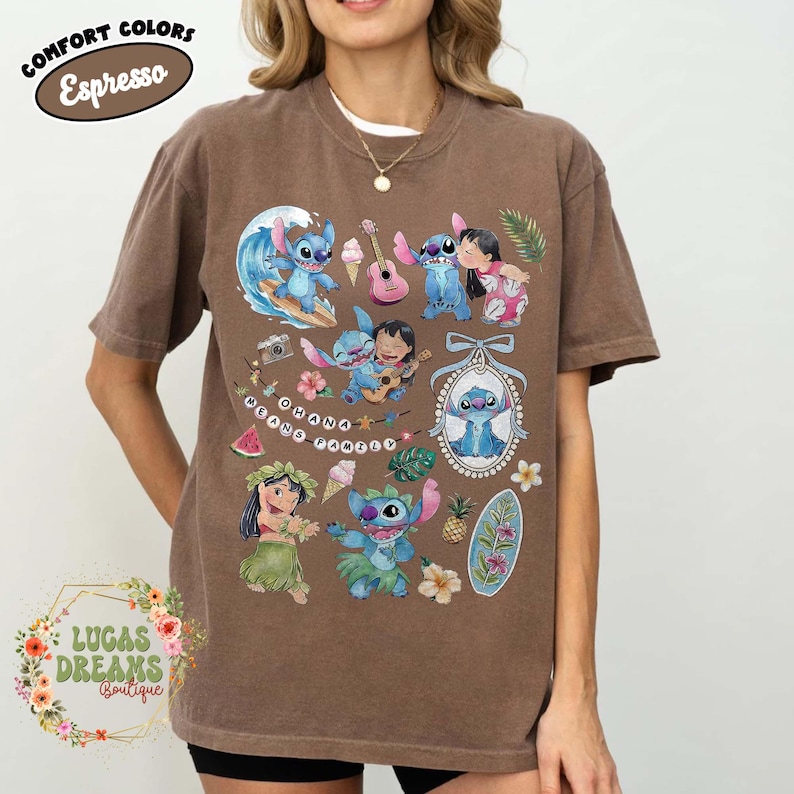 May include: Espresso-colored t-shirt featuring a collage of cartoon characters, including a blue alien surfing a wave, playing a ukulele, and hugging a girl. The shirt has the words "Ohana Means Family" and "Lucas Dreams Boutique."