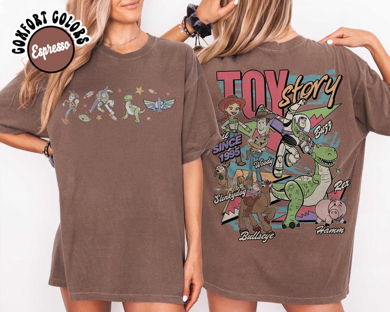 May include: Espresso-coloured t-shirt featuring Toy Story characters. The front displays a line of characters, while the back showcases a larger graphic with the Toy Story logo and more characters. The shirt is a comfort colours style.