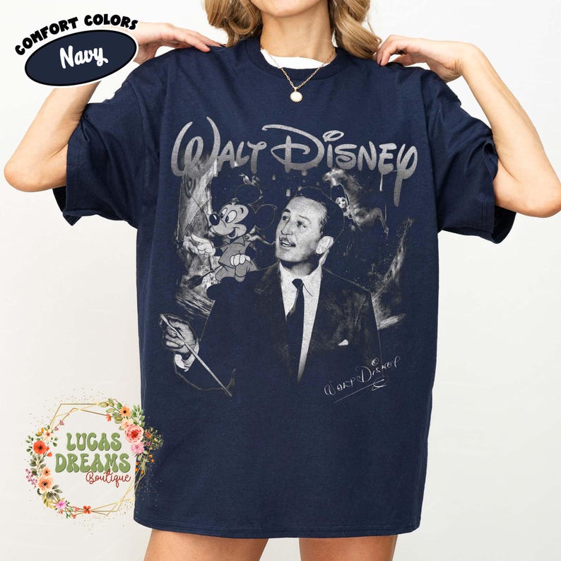 Peut inclure: Un t-shirt bleu marine &agrave; manches courtes avec une impression graphique de Walt Disney et Mickey Mouse. Le texte Walt Disney appara&icirc;t dans une police stylis&eacute;e au-dessus des personnages. Une petite &eacute;tiquette ovale affiche Comfort Colors Navy.
