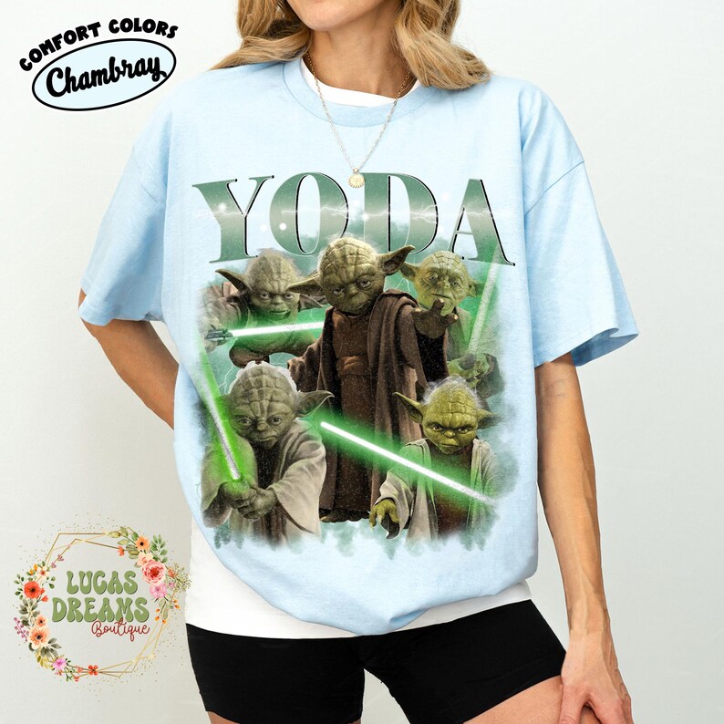 Puede incluir: Una camiseta de manga corta de color azul claro con un estampado gr&aacute;fico del personaje Yoda en varias poses con sables de luz verdes. El texto YODA est&aacute; impreso en letras grandes de color verde sobre las im&aacute;genes. Tiene cuello redondo.