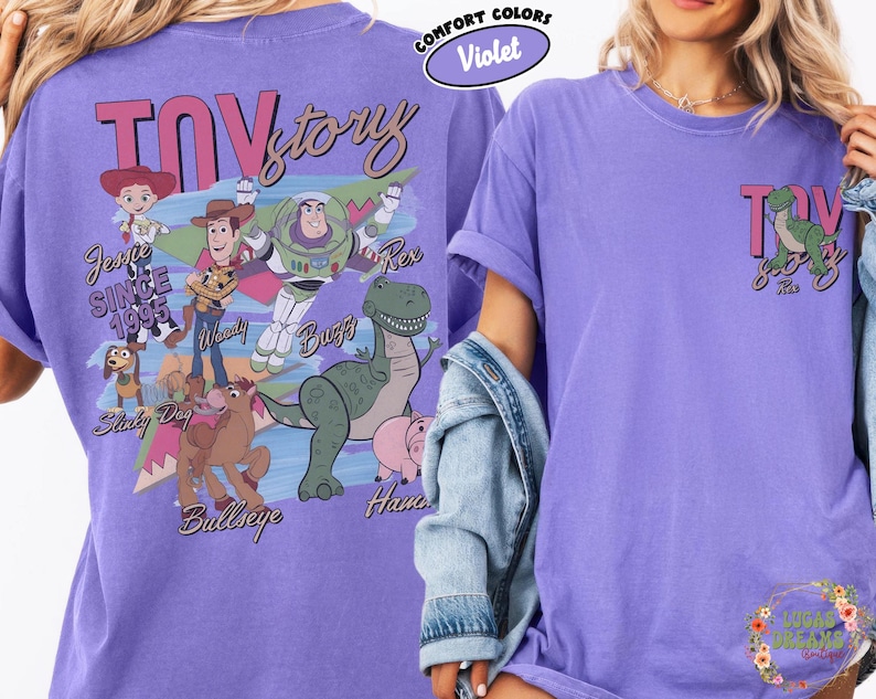 Peut inclure: Un t-shirt violet avec un motif Toy Story repr&eacute;sentant Woody, Buzz l'&Eacute;clair et Rex. Le dos du t-shirt affiche le logo Toy Story et la phrase "Since 1995". Le devant pr&eacute;sente un petit motif Toy Story.