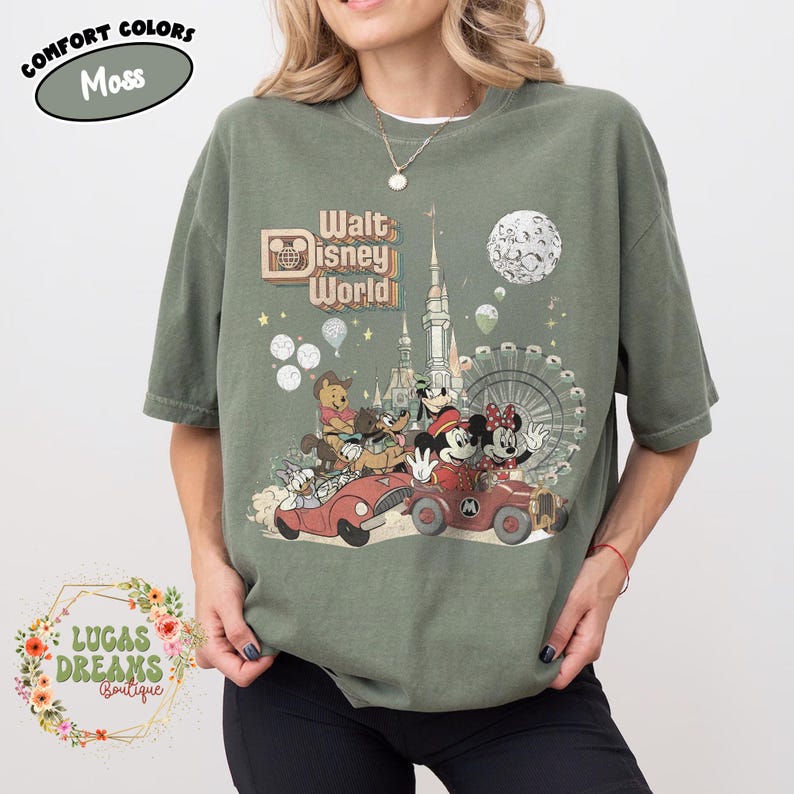 May include: Moss green t-shirt featuring a vintage-style graphic of Walt Disney World characters in cars, with a castle, Ferris wheel, and moon. The shirt includes the text "Walt Disney World" and "Comfort Colors".