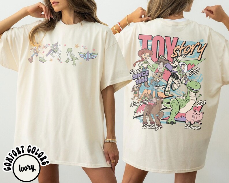 May include: Cream-coloured t-shirt with a Toy Story graphic on the front and back. The front features characters, while the back displays the Toy Story logo, characters, and the text "Since 1995."