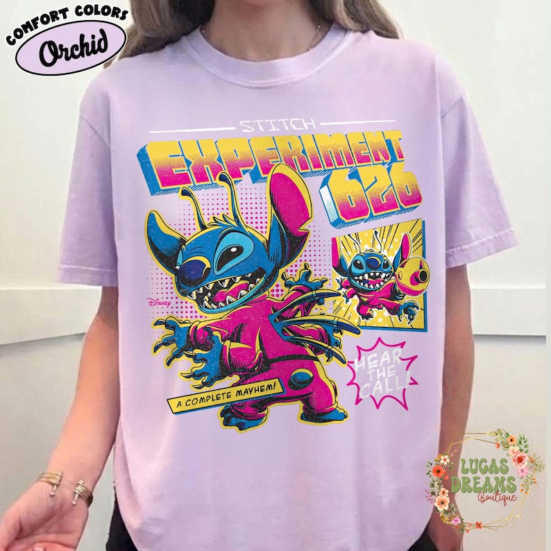 May include: Orchid Comfort Colors t-shirt featuring a graphic of Stitch from Disney's Lilo & Stitch. The design includes the text "Experiment 626" and "A Complete Mayhem!" in vibrant colors. The shirt is a light purple color.