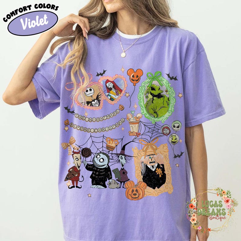 Puede incluir: Camiseta violeta Comfort Colors con un dise&ntilde;o gr&aacute;fico colorido con personajes de Pesadilla antes de Navidad. El dise&ntilde;o incluye a Jack Skellington, Sally, Oogie Boogie y otros personajes en marcos decorativos y elementos tem&aacute;ticos de Halloween.