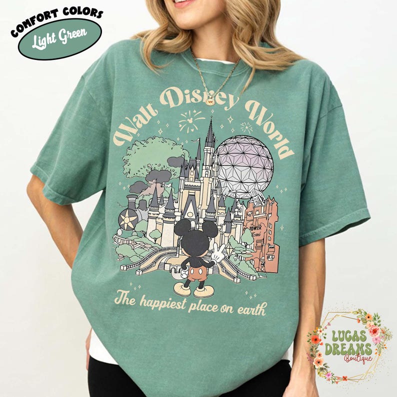 May include: Light green t-shirt with a graphic of Walt Disney World, including a castle, Spaceship Earth, and Mickey Mouse. The text reads "Walt Disney World" and "The happiest place on earth."