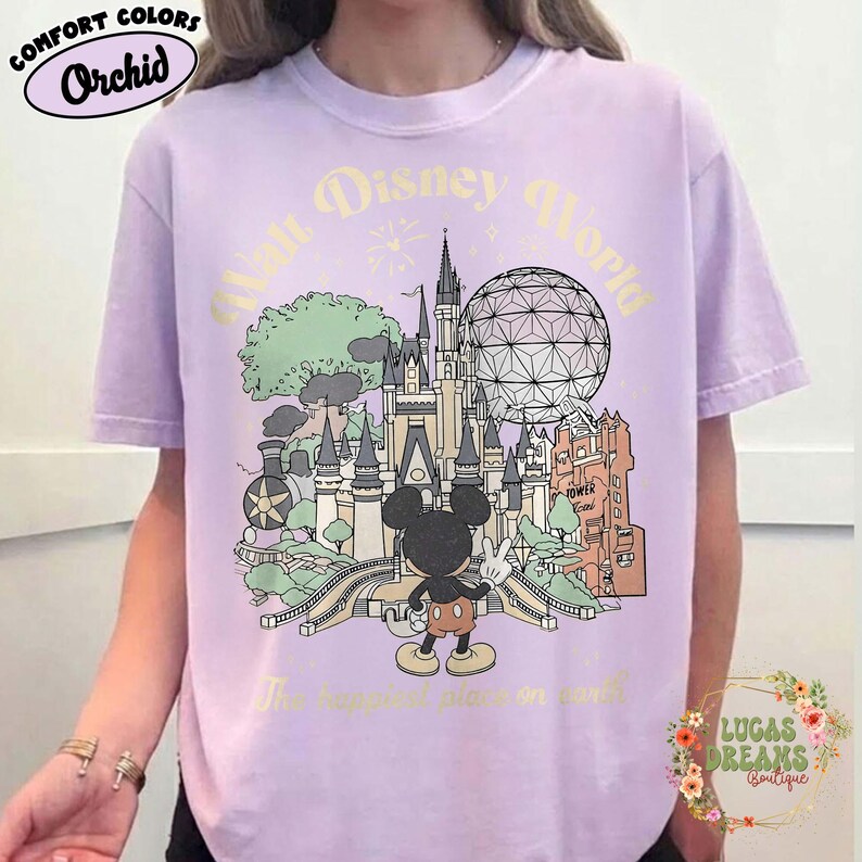 May include: Orchid Comfort Colors t-shirt featuring a vintage-style illustration of Walt Disney World. The design includes Cinderella's castle, Spaceship Earth, and Mickey Mouse. Text reads "Walt Disney World" and "The happiest place on earth."