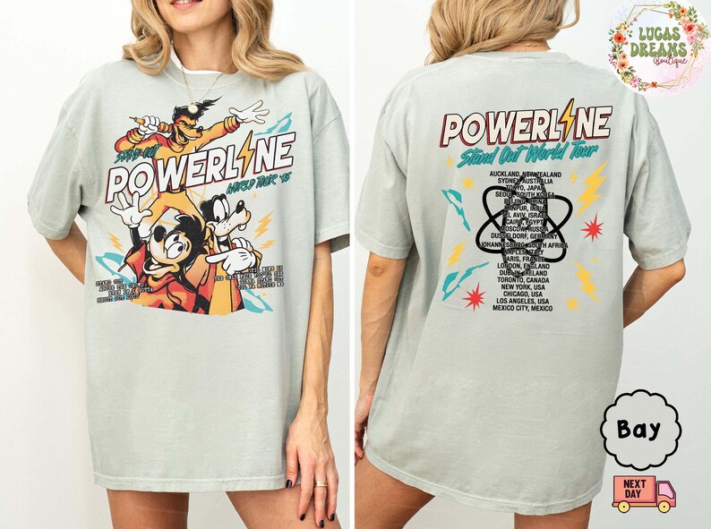 Puede incluir: Camiseta verde claro con un gr&aacute;fico de personajes de dibujos animados y la palabra "POWERLINE". La parte trasera de la camiseta enumera ciudades de una gira mundial. La camiseta tiene un corte holgado.