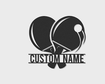 May include: A black graphic design featuring two crossed table tennis paddles and a ball positioned above a horizontal bar containing the text CUSTOM NAME in a bold sans-serif font. The design uses clean lines and solid black shapes.