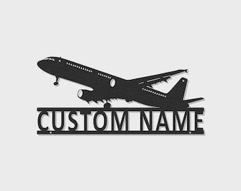 Puede incluir: Un letrero de pared de metal negro que presenta la silueta de un avión comercial en vuelo colocado sobre una barra horizontal que contiene el texto CUSTOM NAME en letras mayúsculas negritas, diseñado para decoración de pared personalizada.
