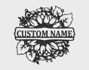 Op de afbeelding: Een zwart metalen wandbord met een cirkelvormig ontwerp van zonnebloemen en bladeren rondom een centrale horizontale rechthoekige banner. De banner bevat de tekst CUSTOM NAME in een vetgedrukt, schreefloos lettertype in het midden.