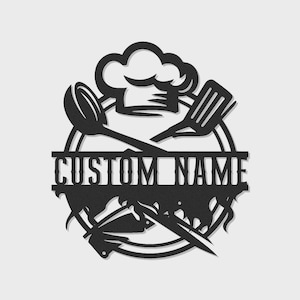 May include: Black metal kitchen sign featuring a chef's hat, spoon, spatula, and knives. The sign is circular with the words "CUSTOM NAME" cut out. A decorative item for a kitchen.
