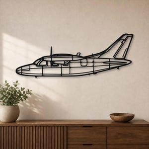 May include: A black metal wall art piece shaped like the side profile of a twin-engine airplane. The design features a hollow, linear frame construction that outlines the fuselage, wings, cockpit windows, and tail section of the aircraft.