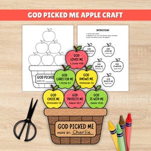 May include: A God Picked Me apple craft kit featuring printable sheets with apple outlines, a basket, and instructions. The finished craft shows a brown basket filled with colored paper apples labeled with religious phrases and Bible verses, plus black scissors and crayons.